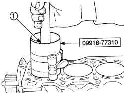 Использование деревянного бруска (1) для установки поршня в цилиндр двигателя